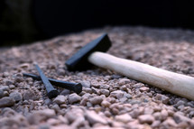 mallet and nails on stones 