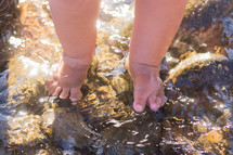 infant feet on wet rocks 