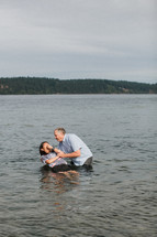 a woman being dunked in a river to be baptized 