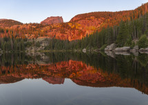 reflections of red rocks on a lake 