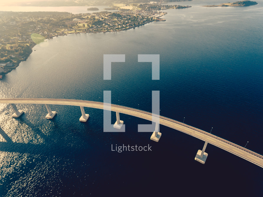 aerial view over a long bridge over water 