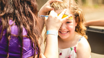 a little girl getting her face painted 
