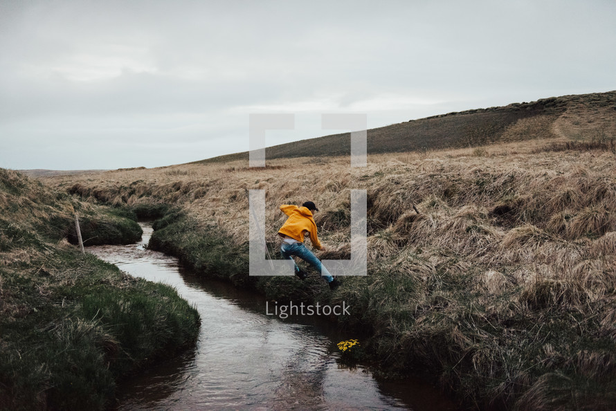 a person jumping over a stream 
