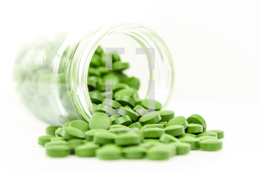 A spilled bottle of green pills. 