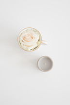 rose in a tea cup and votive candle 