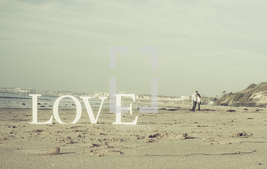 a couple on a beach and the word LOVE