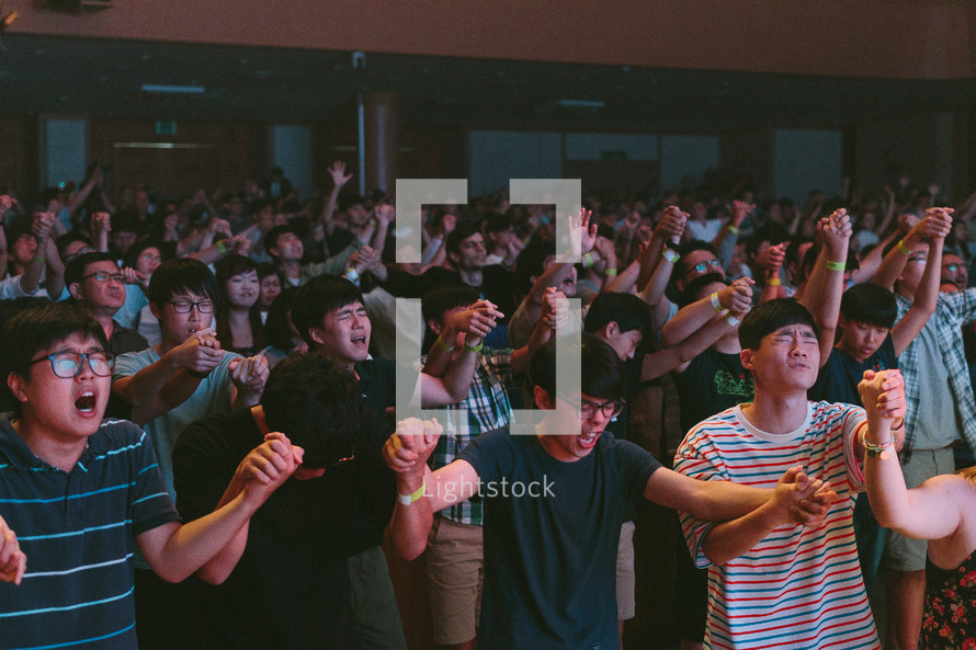 empowered by Christ, youth holding hands and worshiping God 