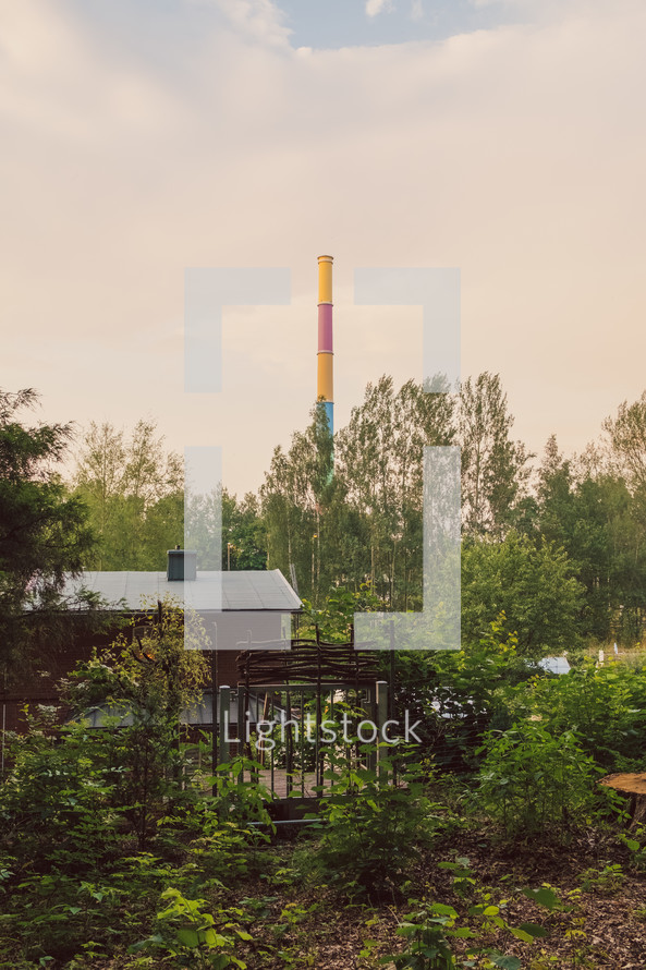 colorful smoke stack in the distance and backyard of a cabin 