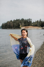 a woman wrapped in a towel after a river baptism 