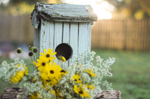 birdhouse and yellow flowers 