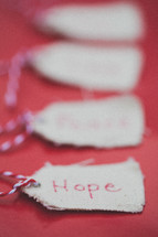 Christmas gift tags, the first one reading "Hope," on a red background.