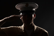 Marine in uniform saluting.