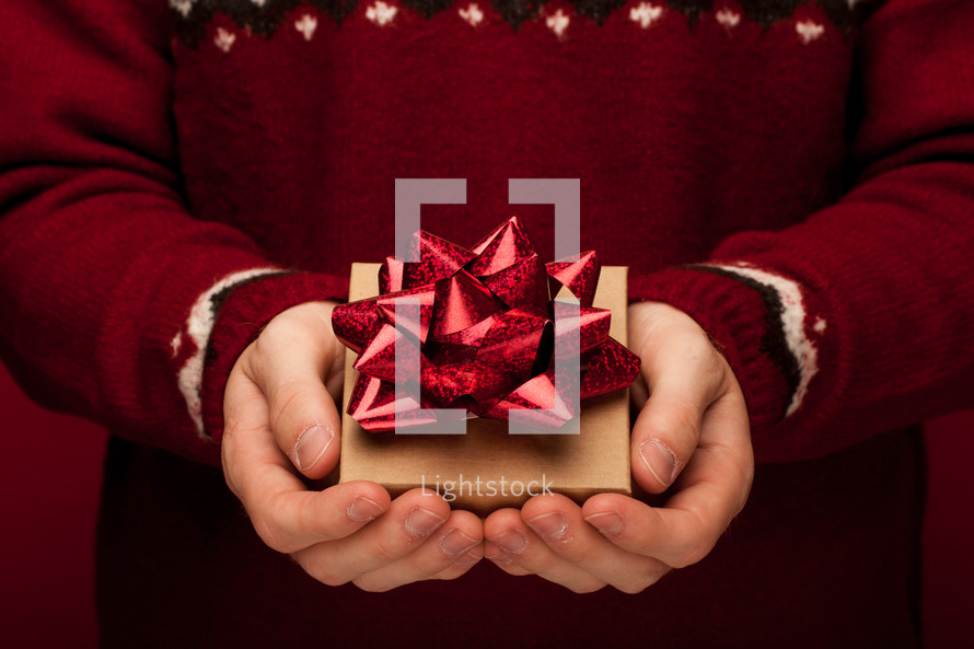 a man holding a Christmas gift in cupped hands 