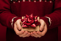 a man holding a Christmas gift in cupped hands 