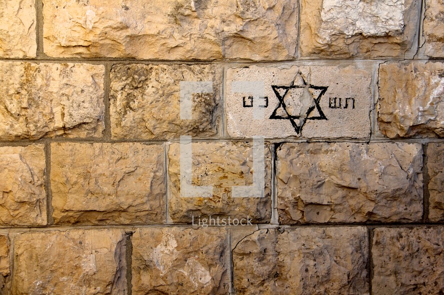 Jewish star of David carved into a brick in a limestone wall in Jerusalem.