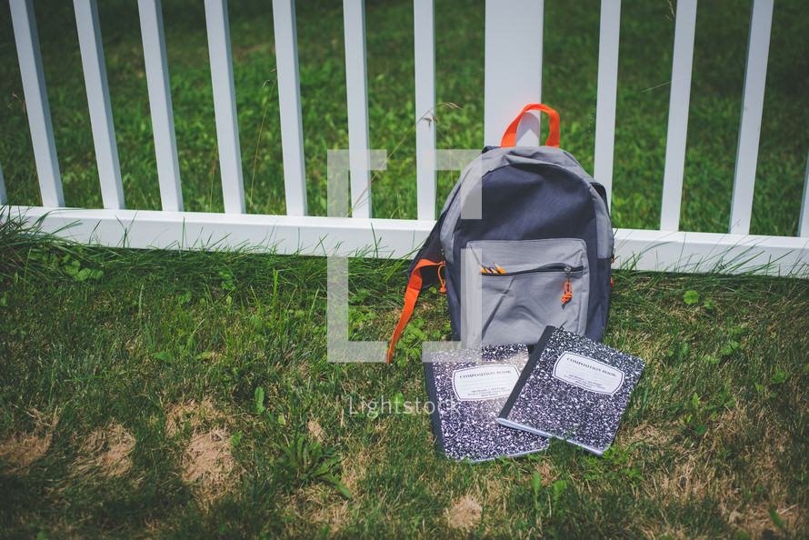 composition notebook in front of a gray book bag 