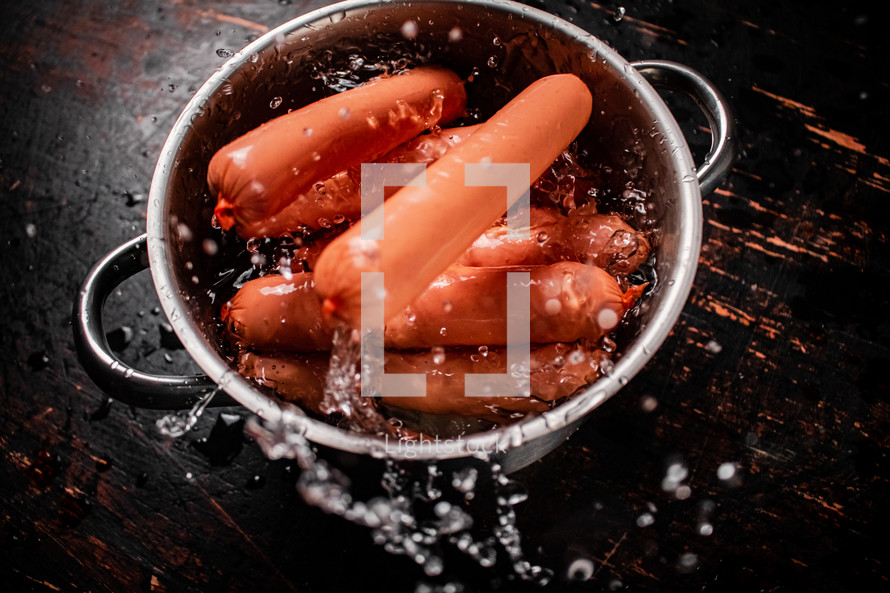 Delicious sausages boiled on the table. On a black background. High quality photo