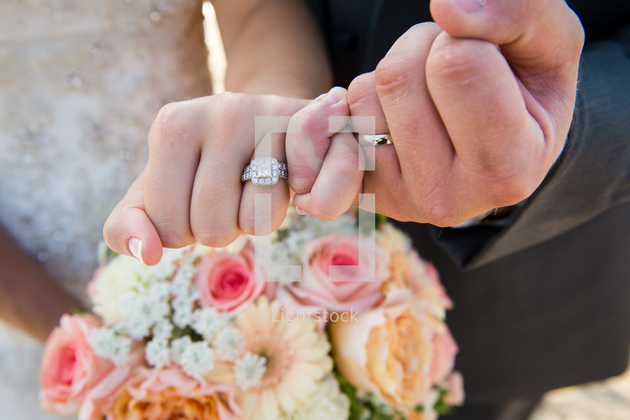 wedding rings on a bride and grooms hands 