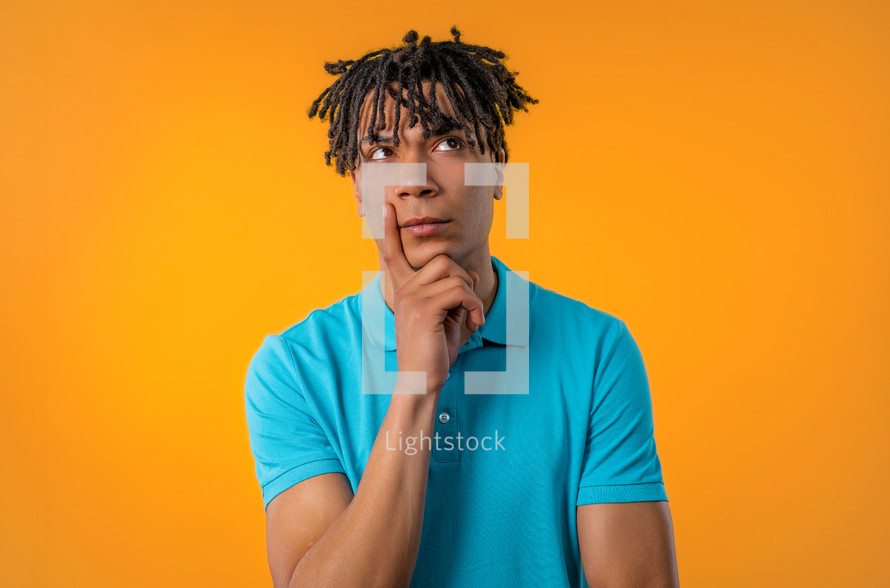 Thinking around man on yellow background. Smart student guy finding answer or trying to remember what he forgot, memory concept. Copy space. High quality photo