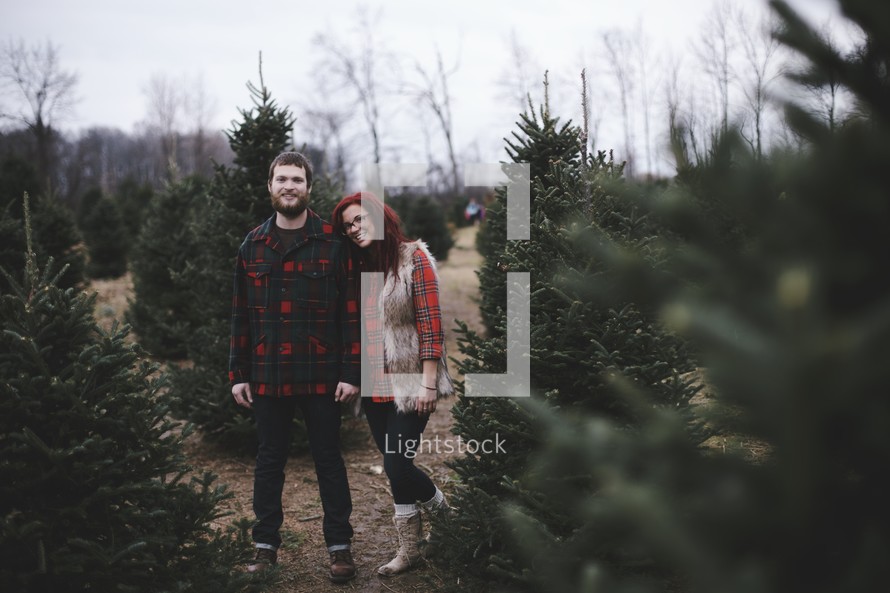 a couple in a Christmas tree lot 
