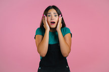 Frightened woman shocked isolated over pink background. Stressed pretty girl because of bad news