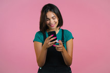 Attractive brunette woman receives happy notification on mobile phone. Girl using smartphone. Technology concept
