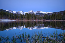 reflection of snow capped mountains in lake water 