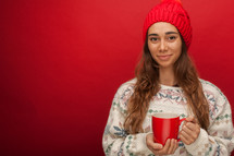 a woman in a sweater holding a mug 