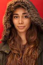a headshot of a woman in a winter coat with a hood 