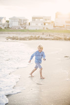 boy child running on a beach 