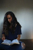 a young woman reading a Bible in her lap 