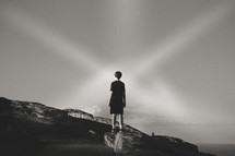 a boy standing on a mountaintop 