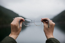 a woman holding out glasses 
