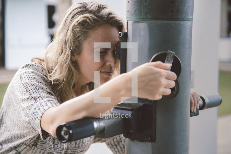 a woman looking out a periscope