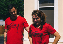 man and woman in red unchained t-shirts 