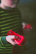 Young boy plays with a pink remote control.