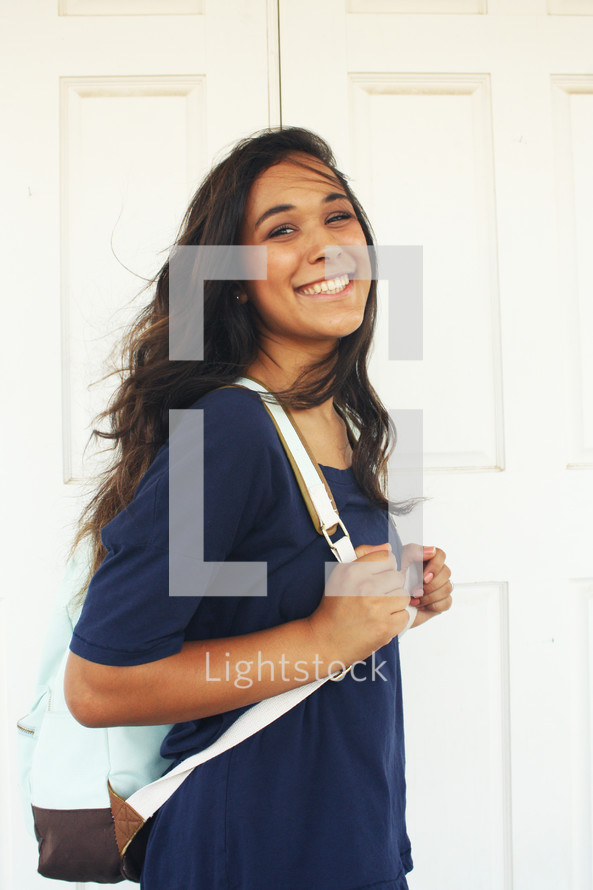 a smiling young woman with a backpack 