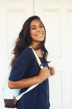 a smiling young woman with a backpack 