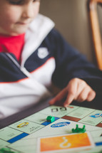 A young boy plays a board game.
