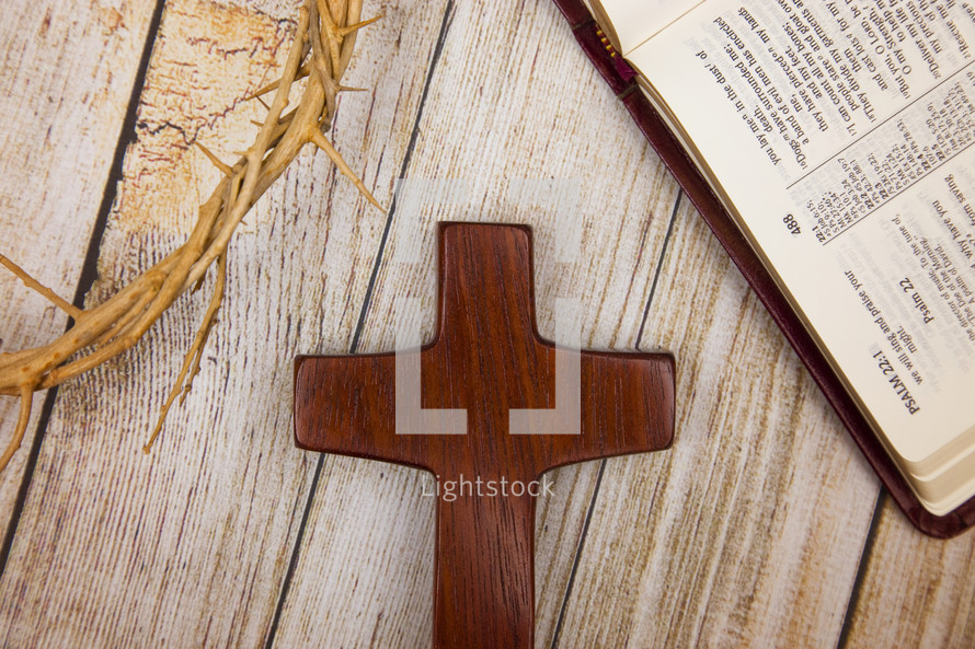 crown of thorns, wooden cross, and open Bible  