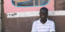 a smiling man sitting outdoors in Haiti 