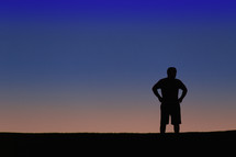silhouette of a man with hands on his hips 