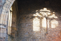 sunlight through a church window on a stone wall 
