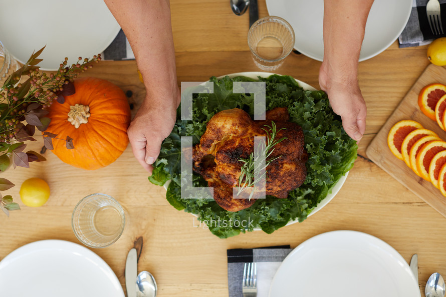 a man putting the turkey on the table 