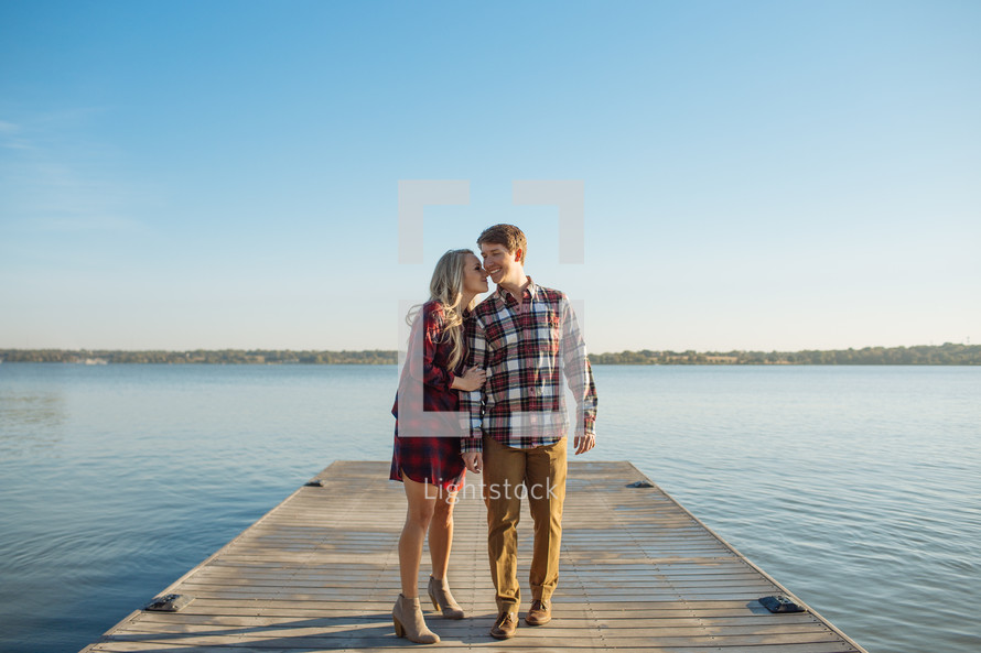 a couple embracing on a dock 