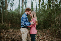 a couple embracing standing in a forest 