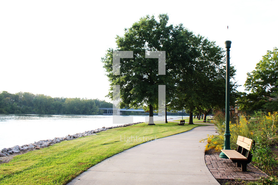 a paved path around a park lake 