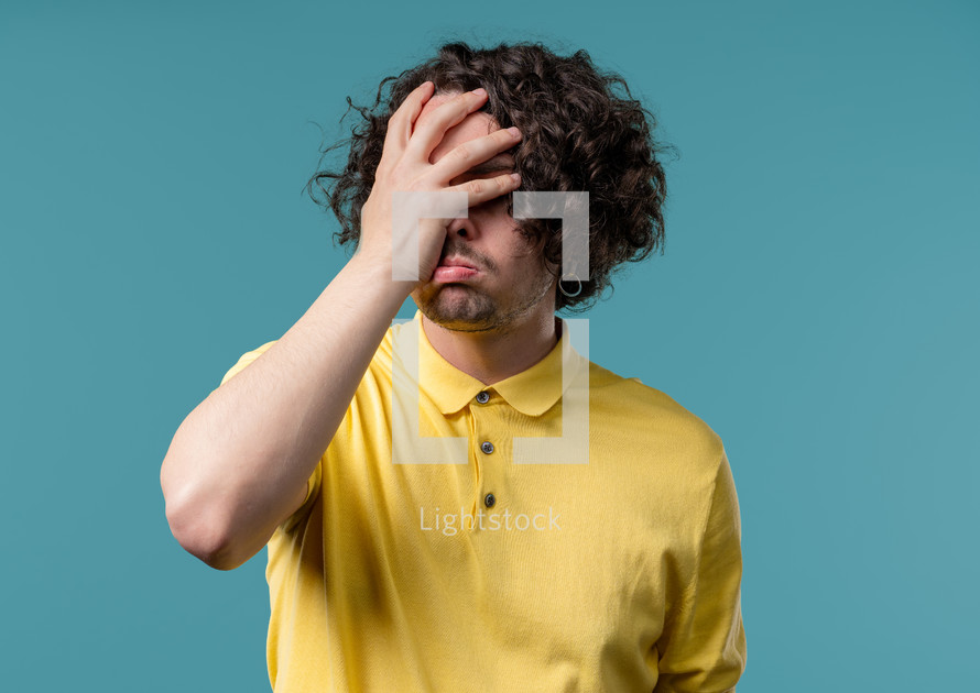 Worried man doing panic despair gesture, like no, I forgot. Disappointed guy feeling sorrow, regret, drama, failure, problems on blue background. High quality