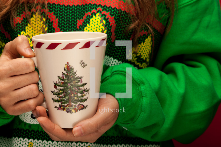 woman in a Christmas shirt holding a mug 