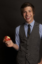 young man taking a bite out of an apple 